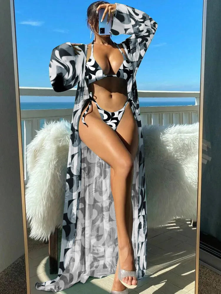 Women's long sleeve bikini set with floral pattern and matching robe on a hanger.