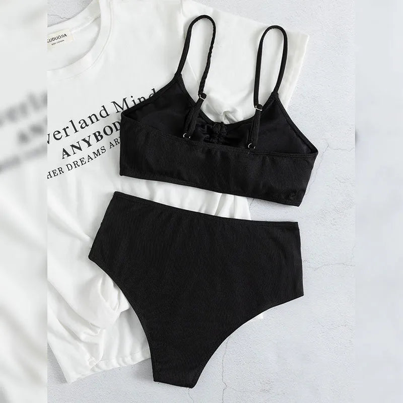 Black women's high-waist bikini with sling split design on shorts and sleeveless top.