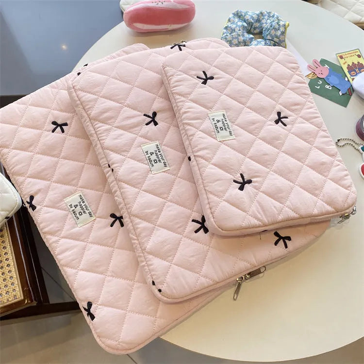 Nylon laptop storage bag with an embroidered rhombus bow in light pink colour.