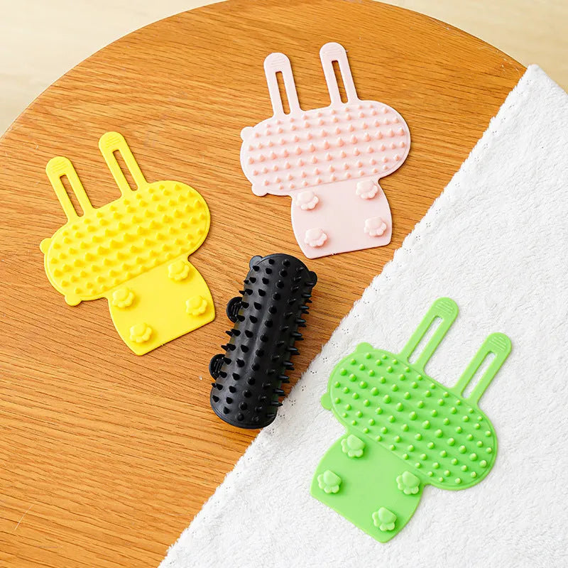 Silicone cat hair removal massage comb attached to a wall corner with rounded teeth for grooming