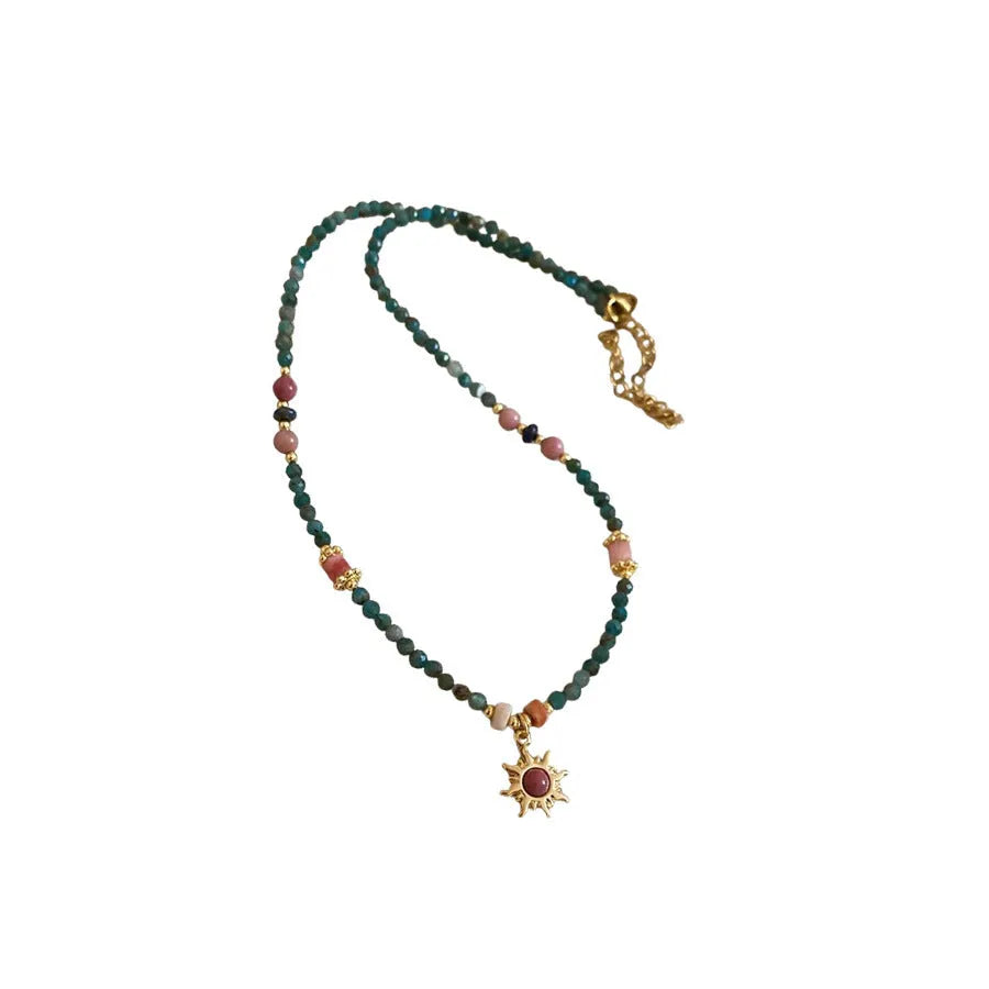 French royal court style necklace with freshwater pearls and a stone sun pendant on an adjustable chain.