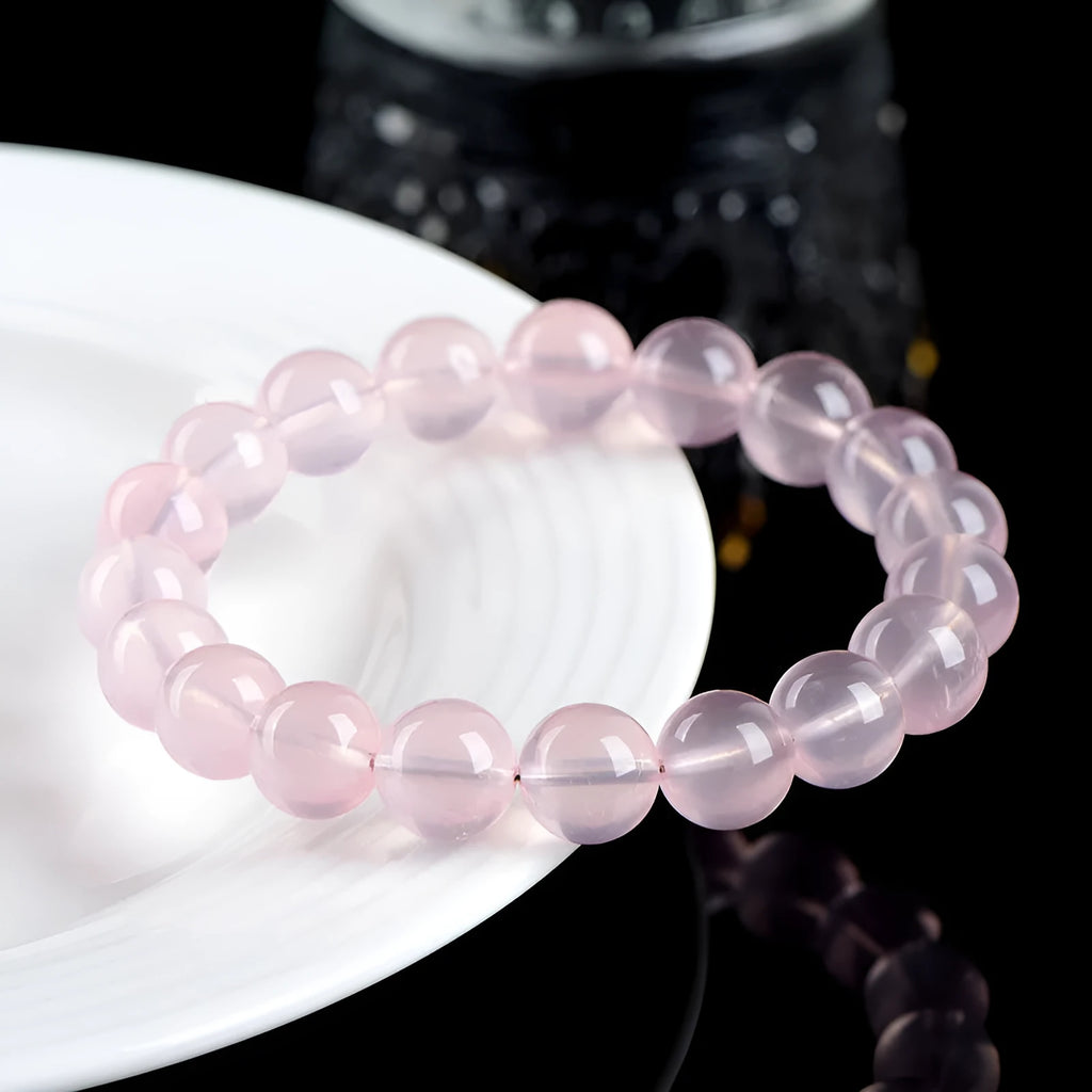 Natural starlight crystal bracelet with round polished pink beads in various size options.