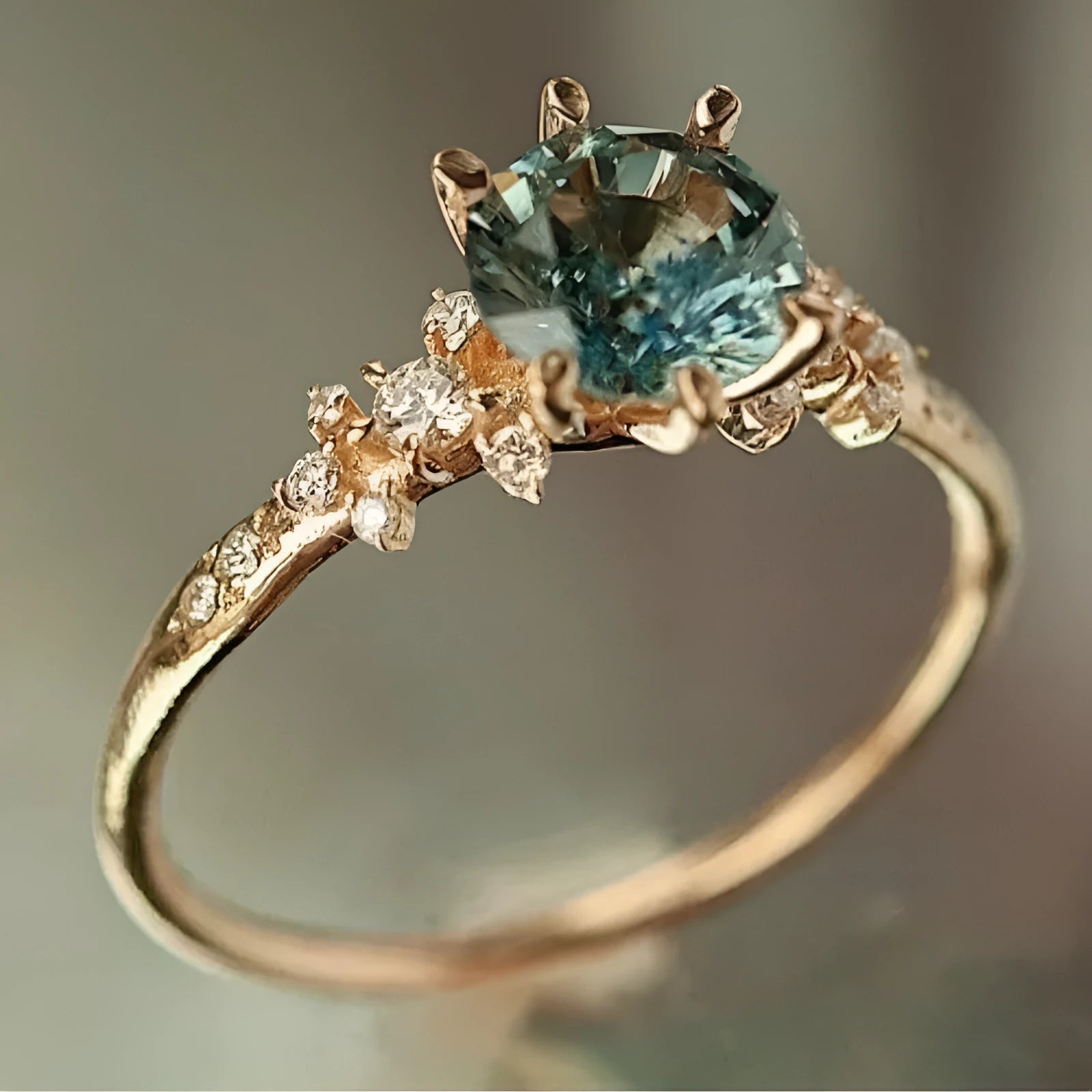Gold geometric ring with a square chamfered pattern and claw-set zircon stones.