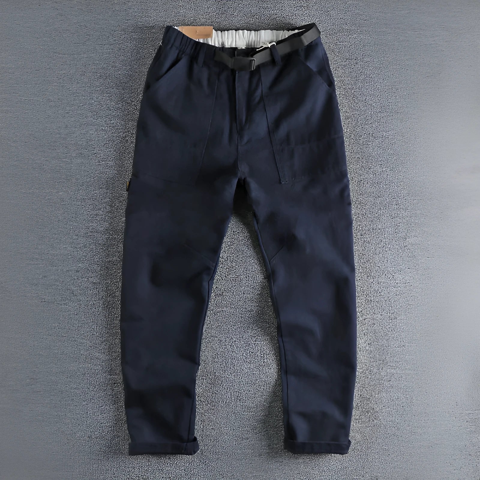 Men's khaki cotton work trousers with a black buckle belt and zip fly closure.