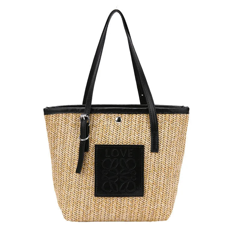 Women's straw woven shoulder bag with PU trim showing tapered shape and sewn thread details