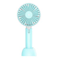 Blue mini handheld USB electric fan with three-speed control on a desk.