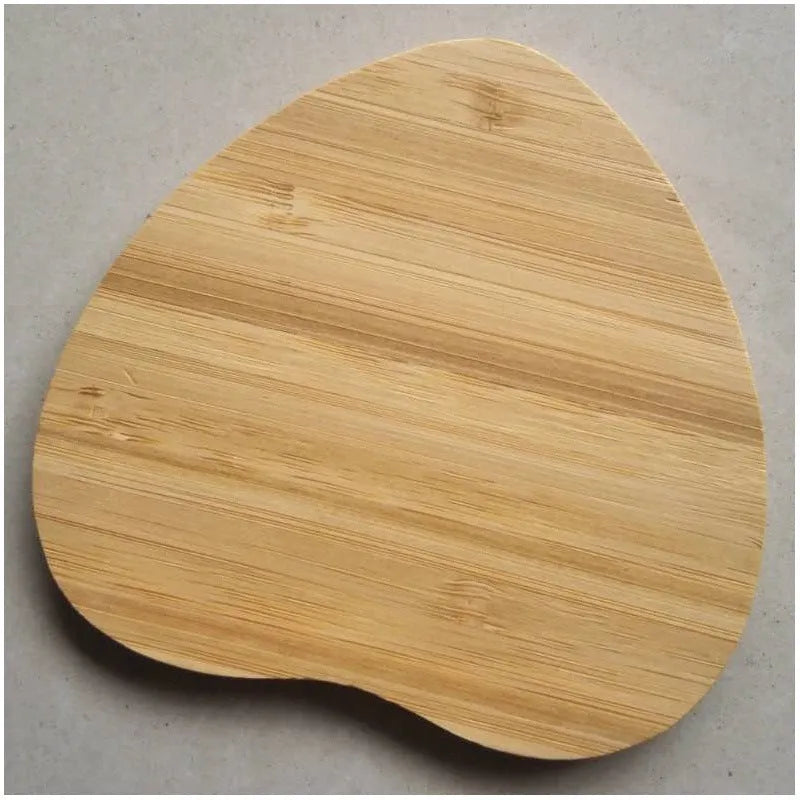 Square wooden bamboo 5W Qi wireless charging pad on a desk next to a smartphone.