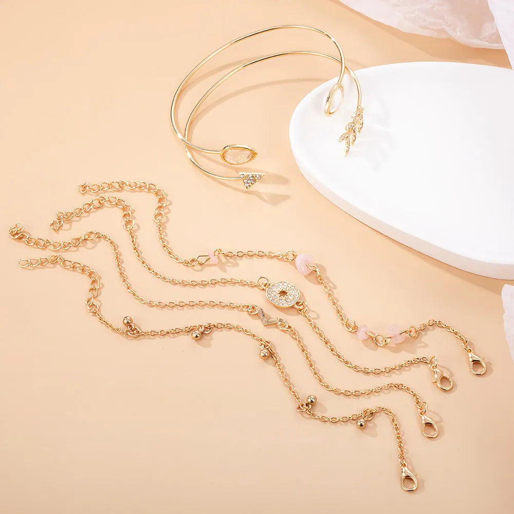 Gold-coloured women's bracelet set with six pieces showing spot drill arrow and water drop V-shaped charms