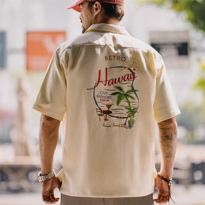Light apricot men's shirt with bamboo plant print and a Cuban collar on a hanger