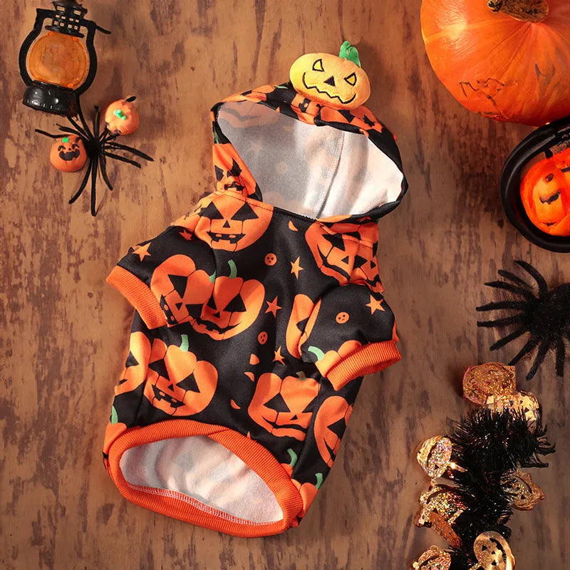 Small dog wearing a orange crystal velvet Halloween pumpkin skirt costume with green leaf accents.