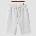 Men's beige linen casual shorts with a loose fit and cropped length on a plain background.