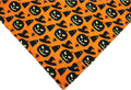 Reversible Halloween dog bandana showing pumpkin and spider web patterns with adjustable neck fastening