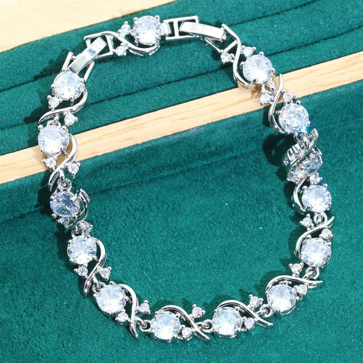 Four-piece bridal jewellery set showing zircon necklace, bracelet, earrings and ring with water wave chain design