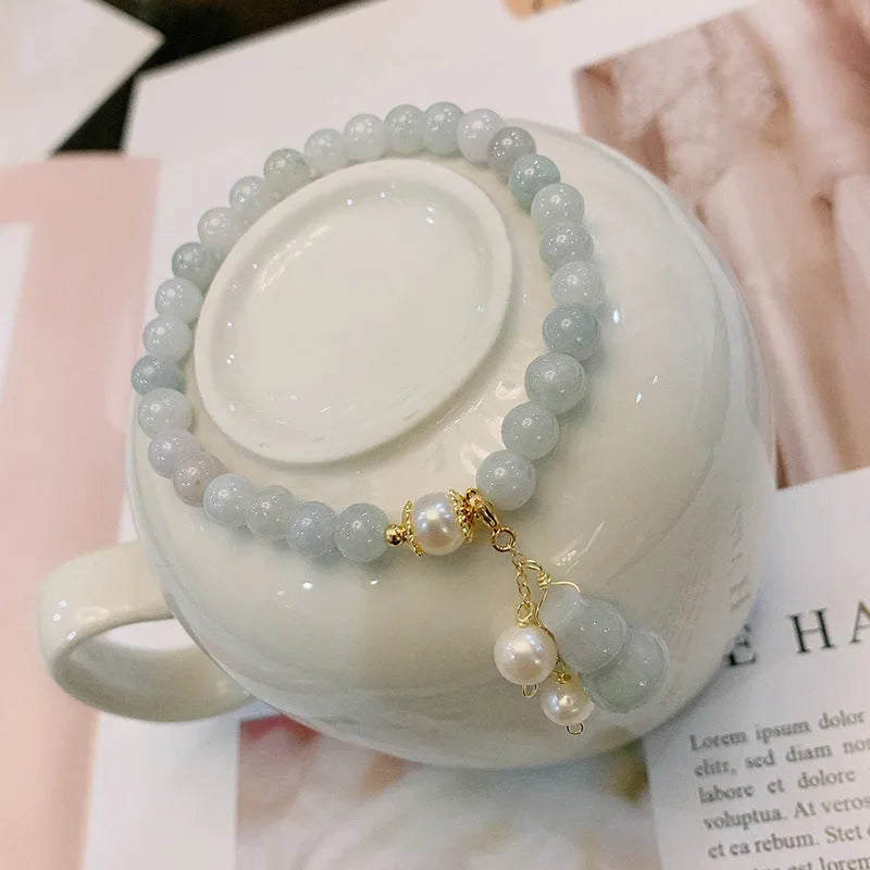 Close-up of a natural emerald jade bracelet with a detailed pearl jade gourd charm pendant.