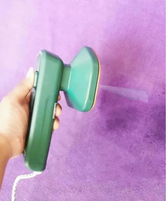 Dark green portable hanging steam iron with ceramic panel and power cord.