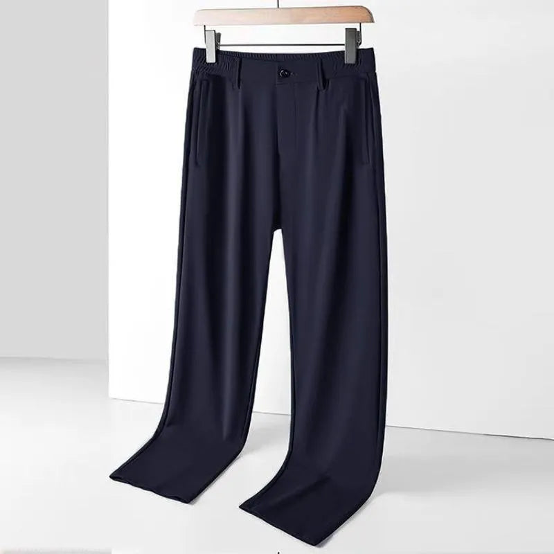 Men's black ice silk leisure trousers with elastic waist and straight leg design laid flat