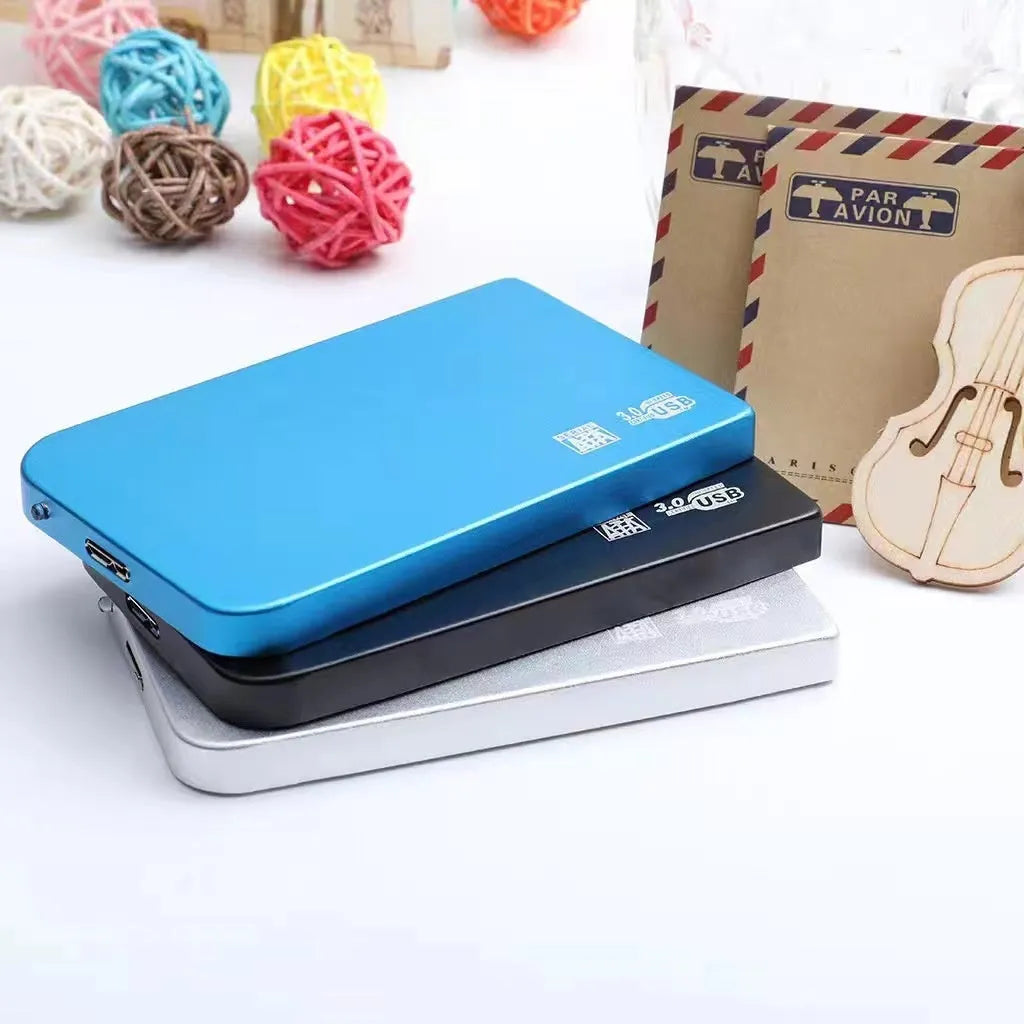 Silver metal external solid state drive with USB cable and cover next to packaging.