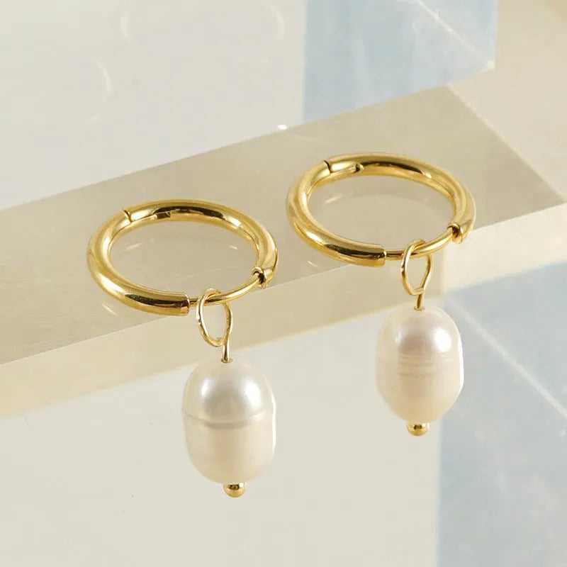 Gold geometric women's earrings made from stainless steel with a central pearl and titanium posts.