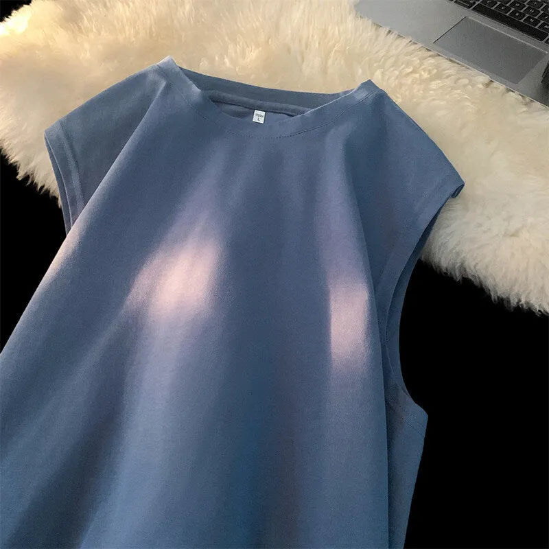 Men's loose solid colour sleeveless cotton tank top on a hanger, shown in a light apricot shade.