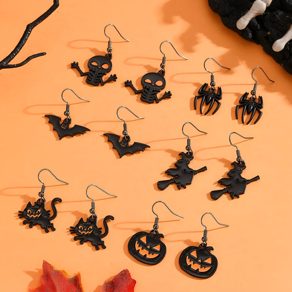 Set of six Halloween earrings with bat, cat, pumpkin head, skeleton, spider, and witch motifs on a dark background