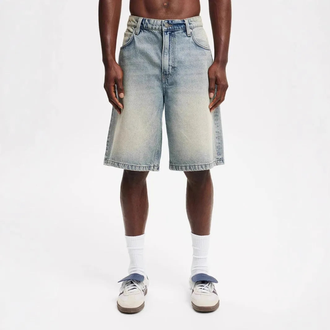Man wearing loose fit light blue straight leg denim jeans, a streetwear summer style.