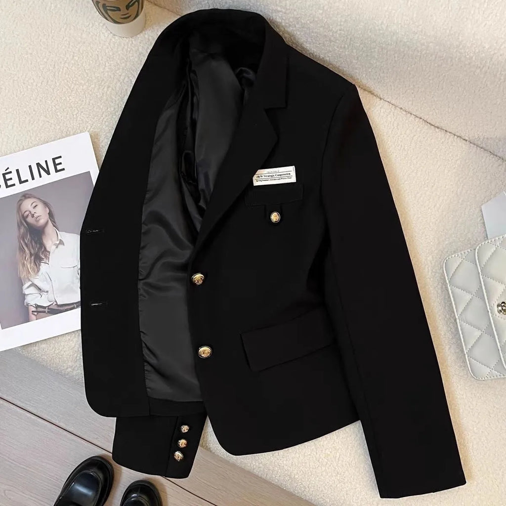 Women's loose fit short suit coat in black polyester fabric with pockets.
