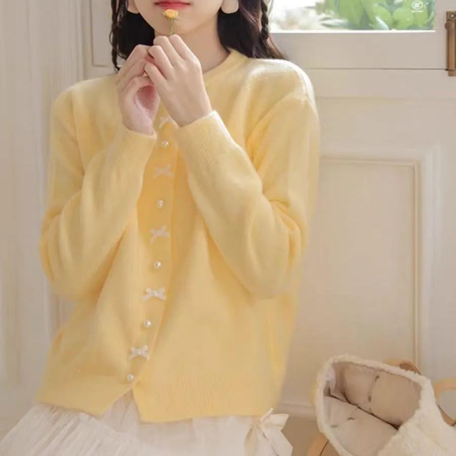 Women's solid colour cardigan sweater with bow and pearl button design in medium thickness fabric
