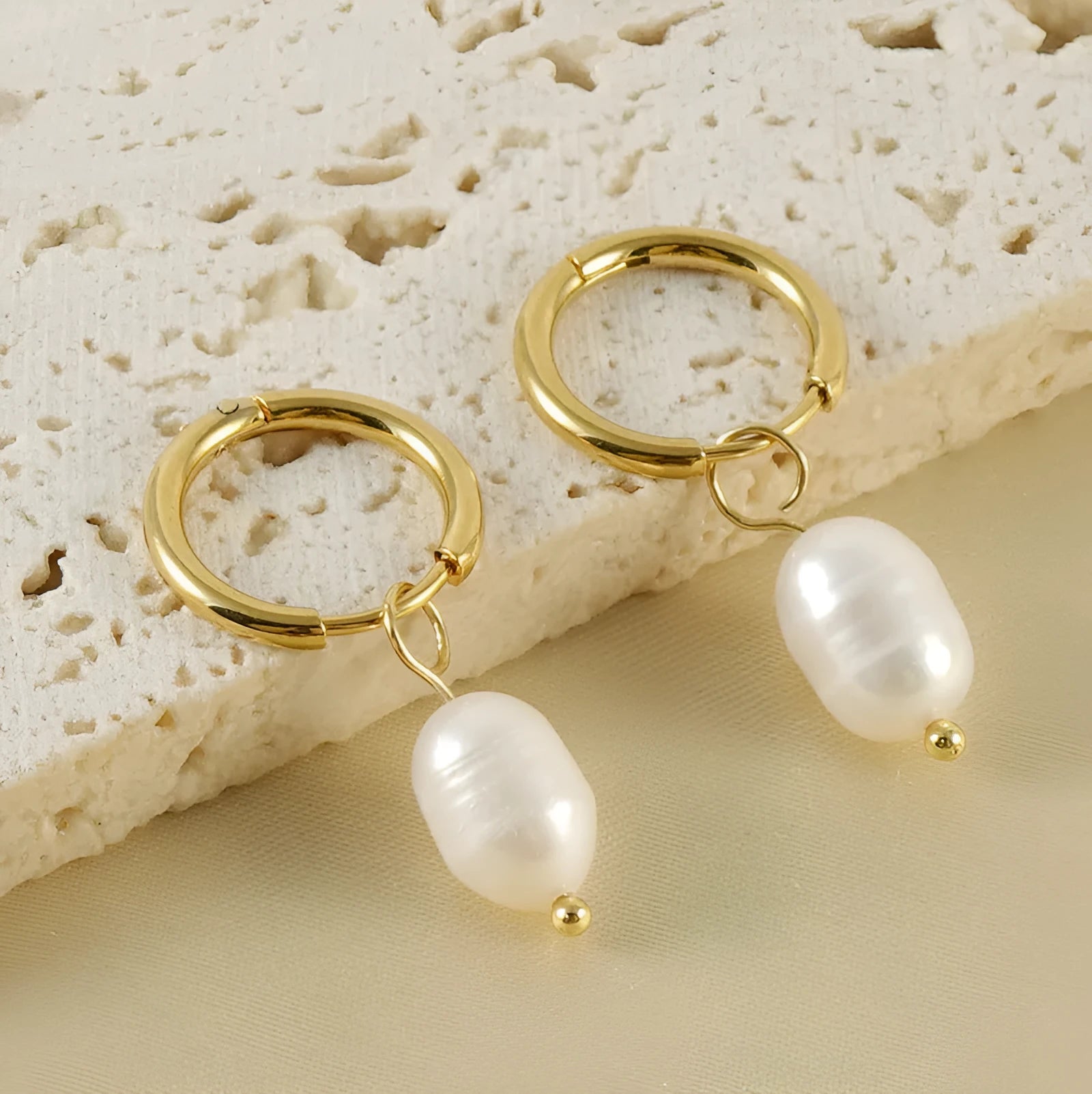 Gold geometric women's earrings made from stainless steel with a central pearl and titanium posts.
