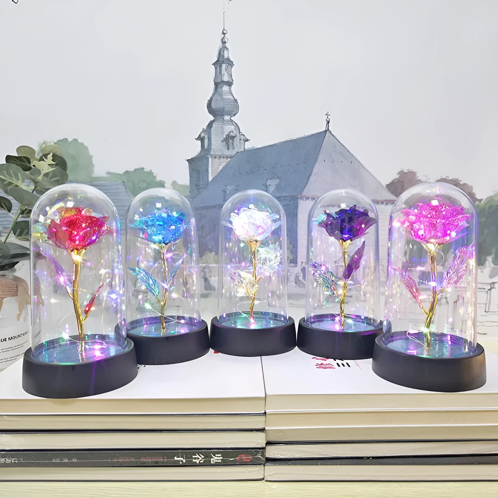Small decorative table lamp with coloured LED lights illuminating plastic flowers under a glass dome.