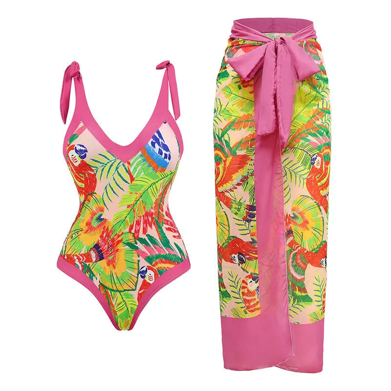 Pink floral print women's one-piece swimsuit with V-neck and matching skirt on beach
