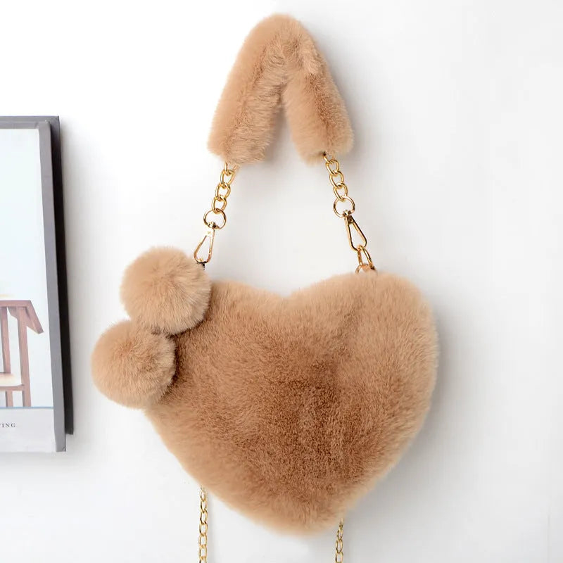 A soft, heart-shaped plush handbag for women in a medium size with a detachable shoulder strap.