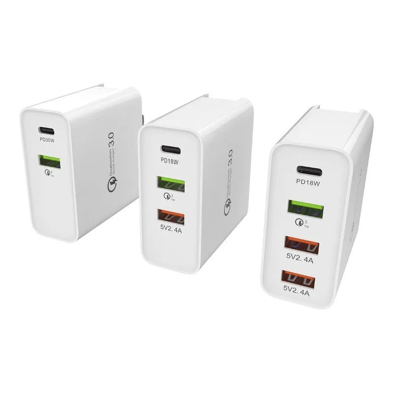White multi-port USB fast charger with UK plug showing PD and QC ports on a table.