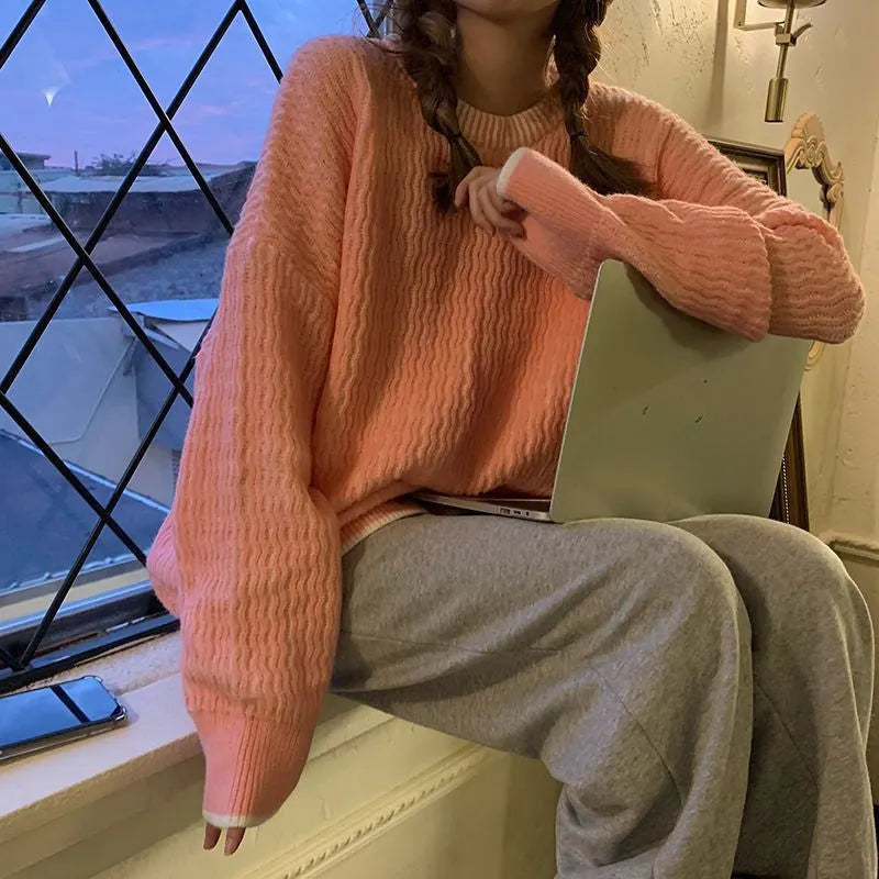 A woman's loose-fit solid colour pullover sweater in a retro style, shown in lake blue.