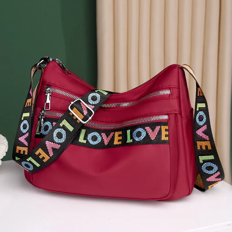 Soft oxford cloth crossbody shoulder bag with multiple pockets, letter stitching, available in black and red