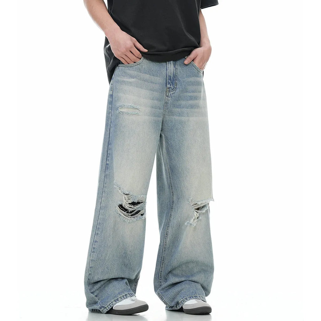 Blue men's straight-leg jeans with ripped distressing on the thigh, showing five-pocket design and zip fly.