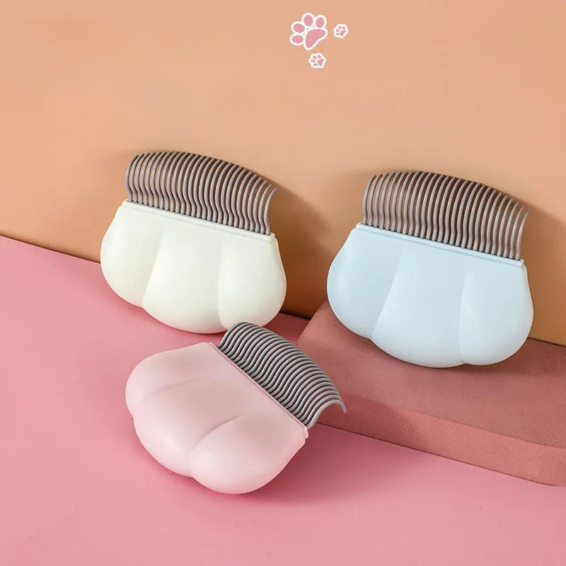 Paw Soft deshedding brush grooming tool for cats and dogs on a white surface.