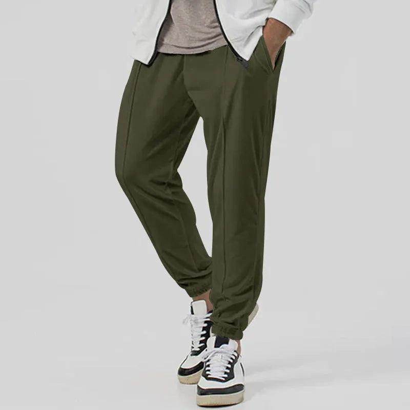 Men's grey loose tapered track sweatpants with elastic waist and straight leg design.