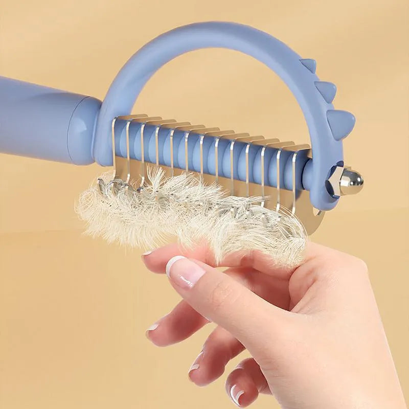Blue dinosaur-shaped self-cleaning cat brush with double-sided stainless steel bristles