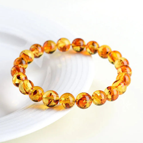 Natural yellow piebald amber bracelet with geometric beads on wrist
