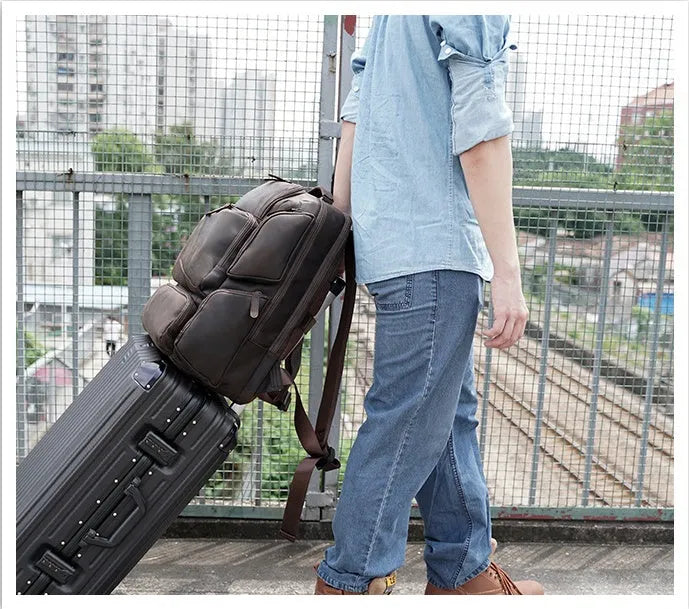Dark brown retro crazy horse leather men's backpack open to show 17-inch laptop compartment and internal pockets.