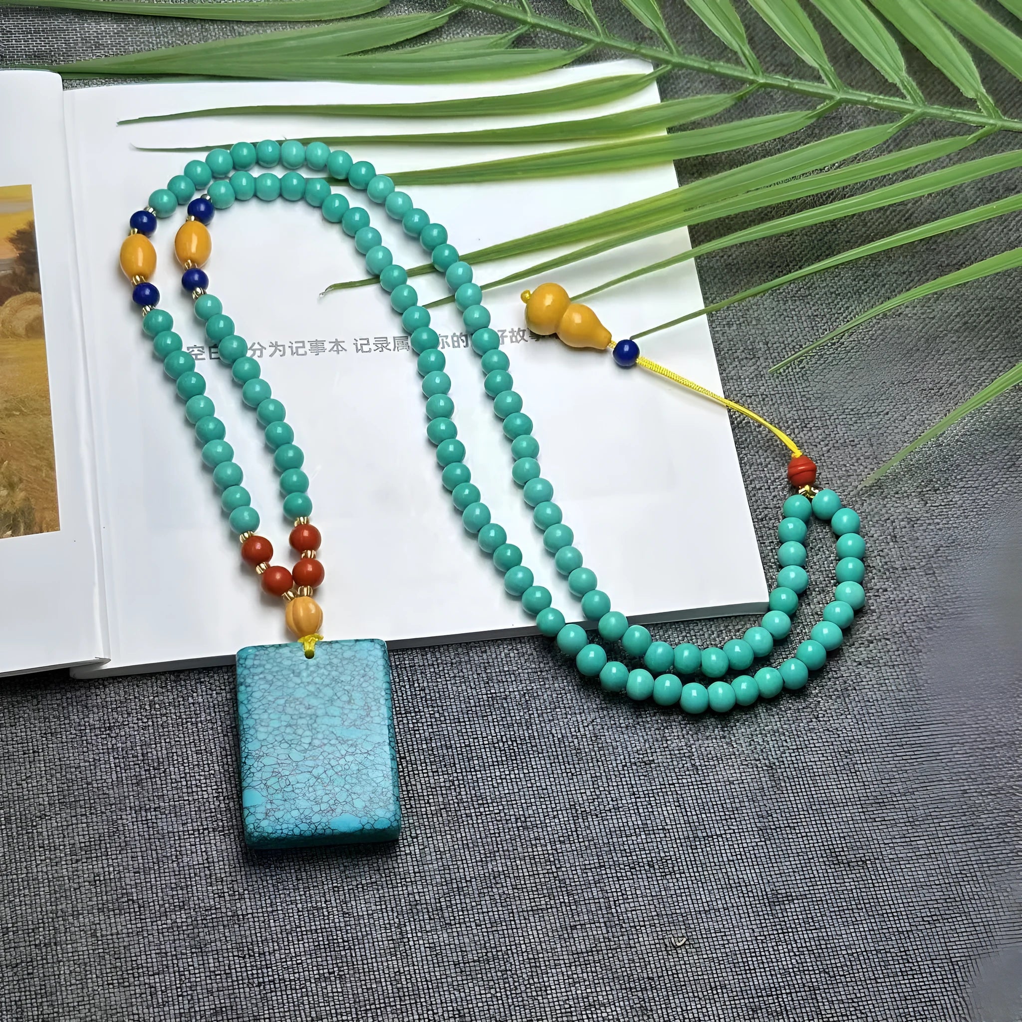 Hand-woven turquoise mesh flower lucky pendant on an adjustable ball bead necklace chain.