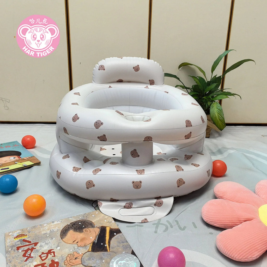 Inflatable infant dining chair in PVC with bear design, deflated beside a baby for scale