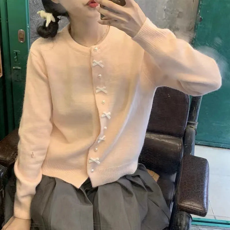 Women's solid colour cardigan sweater with bow and pearl button design in medium thickness fabric