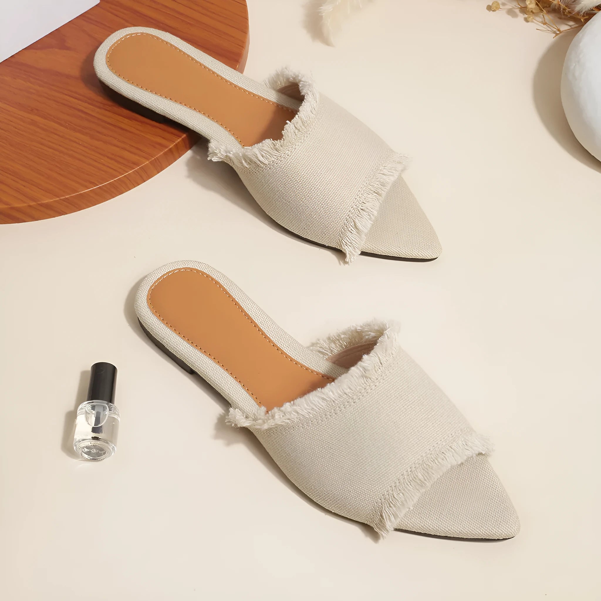 Solid colour denim women's slippers with a tassel detail, showing leather lining and PVC sole.