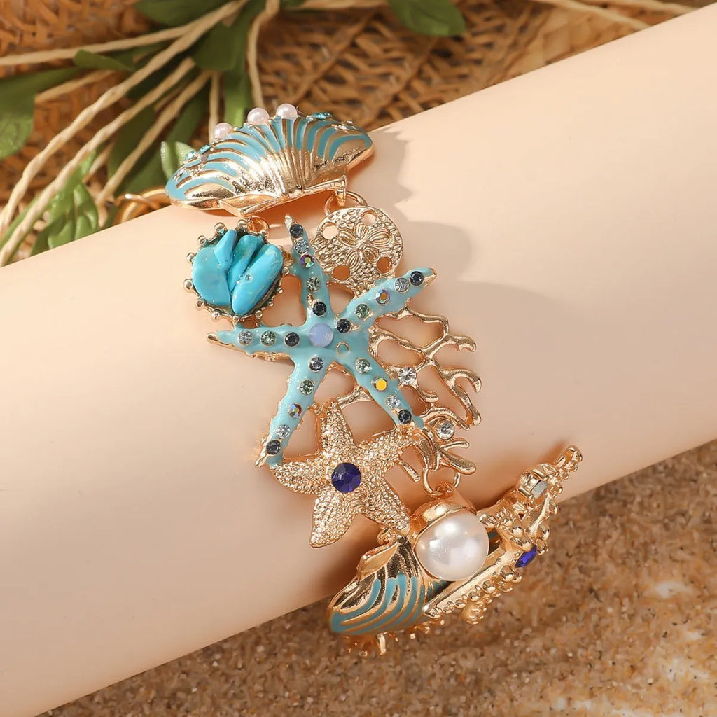 Women's alloy bracelet with a rhinestone-studded boat anchor and starfish charm in blue, red, or turquoise.