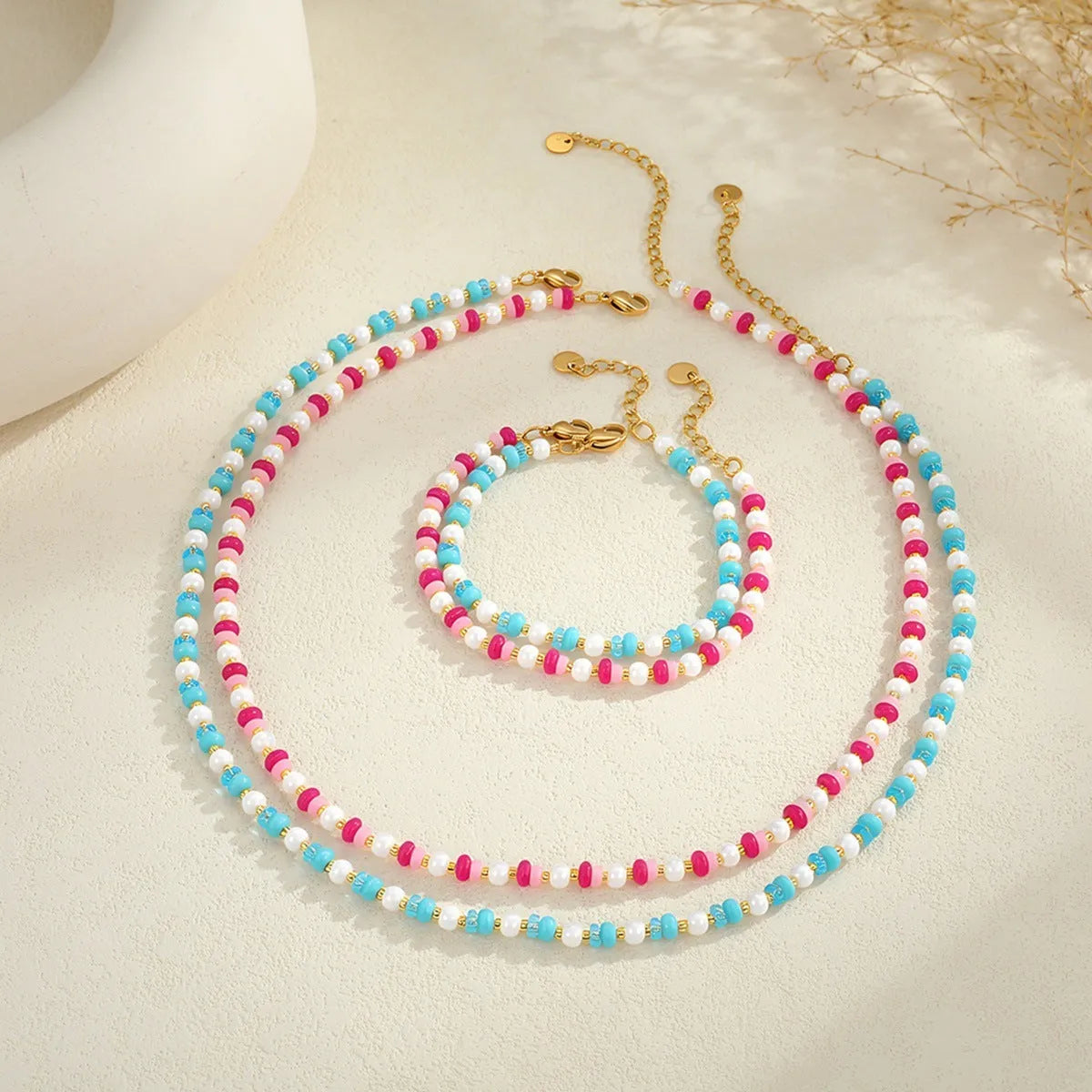 18K gold plated stainless steel chain necklace with pink electroplated resin bead pendant on white background
