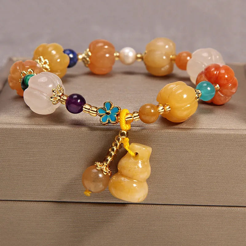 Yellow agate crystal bracelet with gold silk adjustable cord on a wrist, showing khaki coloured beads.