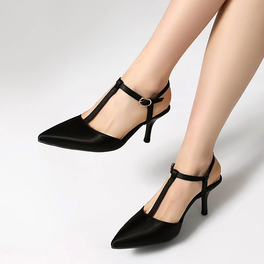 Women's pointed T-strap high heels in top grain leather, black colour, side view on plain background