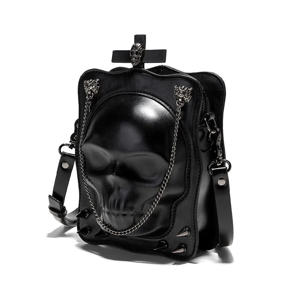Black mini square messenger bag with embossed skull design, featuring stitching, rivets, chain details and zipper closure