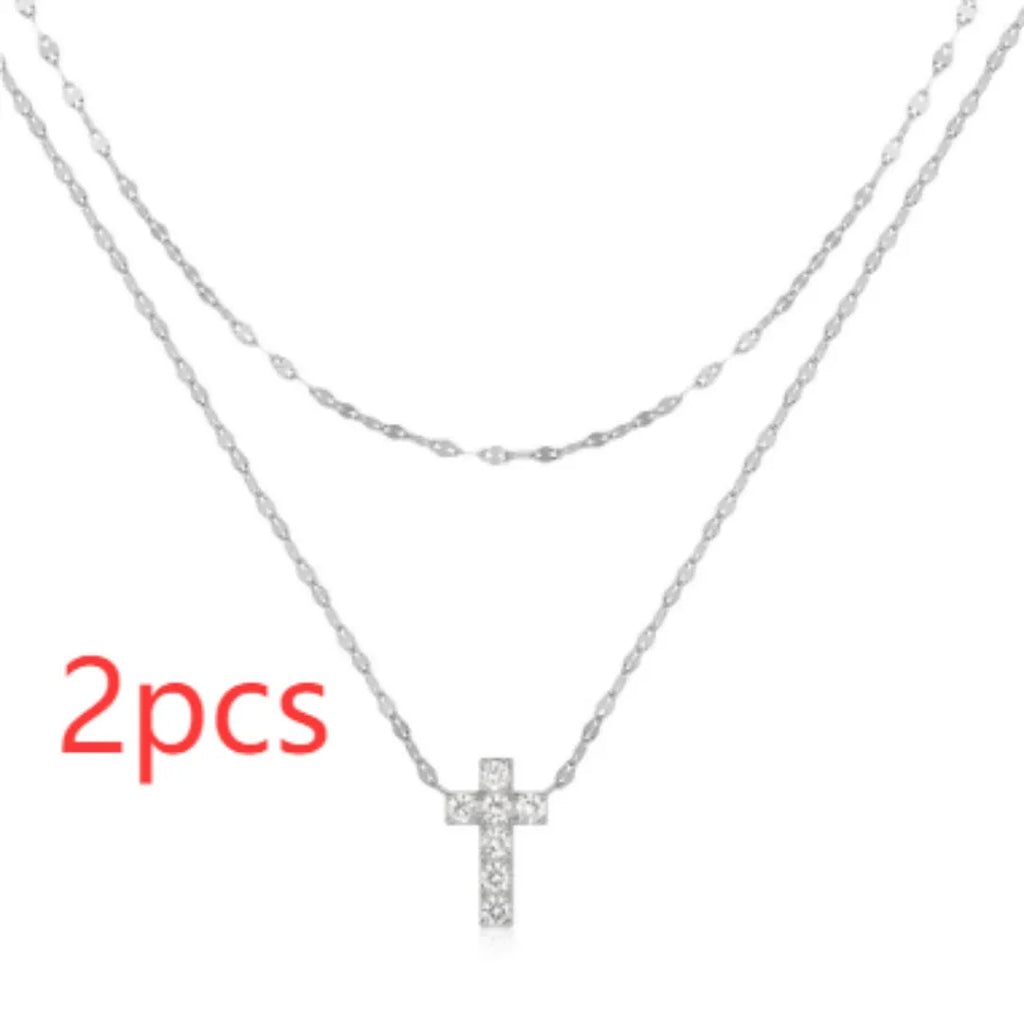 S925 sterling silver double layer twin diamond cross pendant necklace on a clavicle chain, shown in gold and white gold colour finishes.